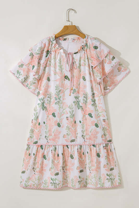 Robe courte rose à fleurs, manches volantées, encolure froncée et jupe évasée.