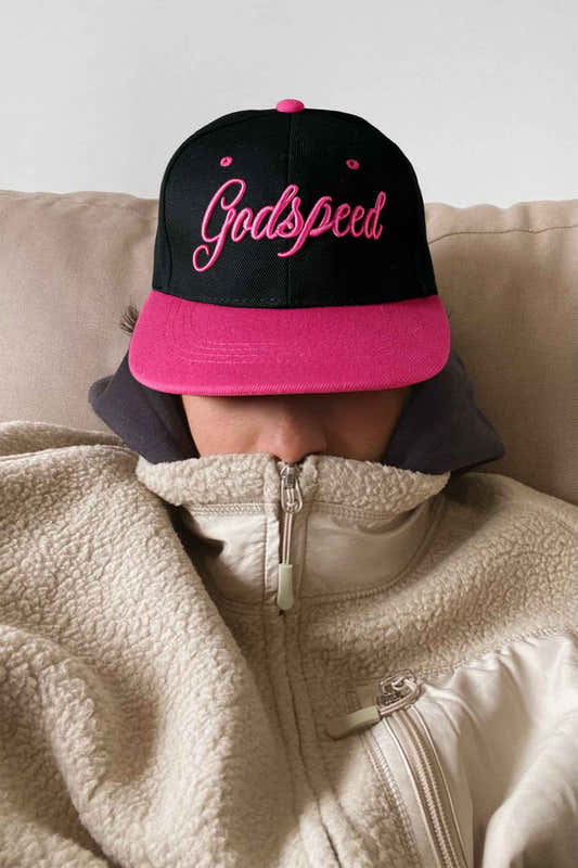 Casquette de baseball noire avec visière fuchsia, broderie rose « Godspeed ».
