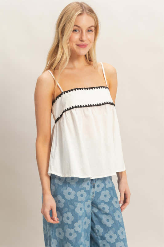 Haut babydoll sans manches blanc avec bordure festonnée noire et buste froncé