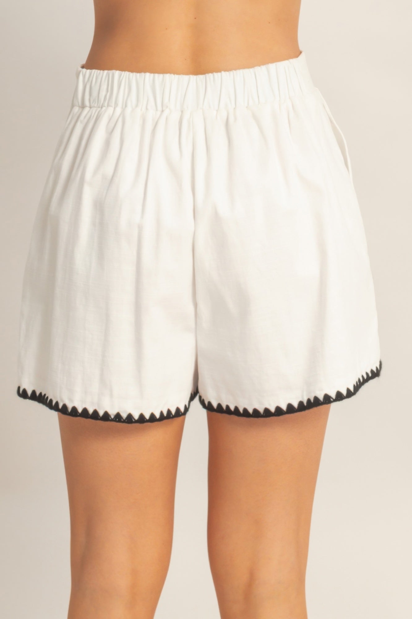Shorts taille haute blancs à taille élastique et bord festonné noir