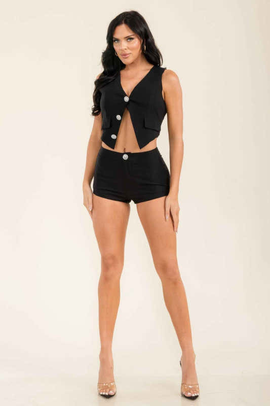 Ensemble deux pièces noir : haut sans manches boutonné et short avec poches latérales.