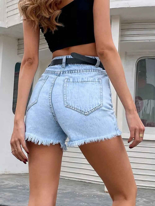 Short en jean bleu clair taille haute, rabats et ceinture noire, déchirures aux genoux.
