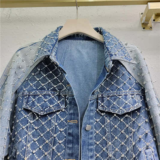 Veste en jean bleu claire ornée de strass, deux poches boutonnées, vue avant