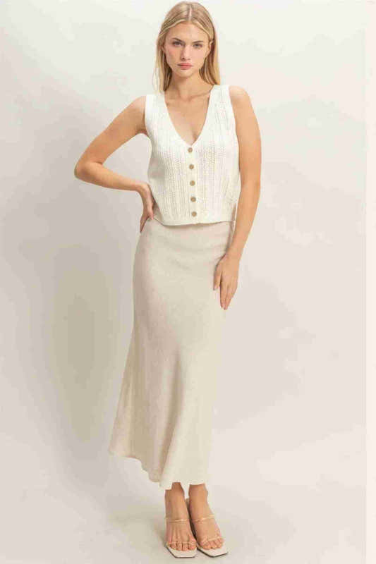 Débardeur femme blanc en maille côtelée, col V, patte de boutonnage sur le devant.