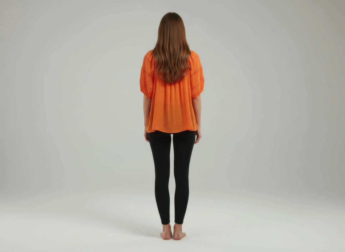 Haut femme orange vu de dos, encolure froncée et manches bouffantes