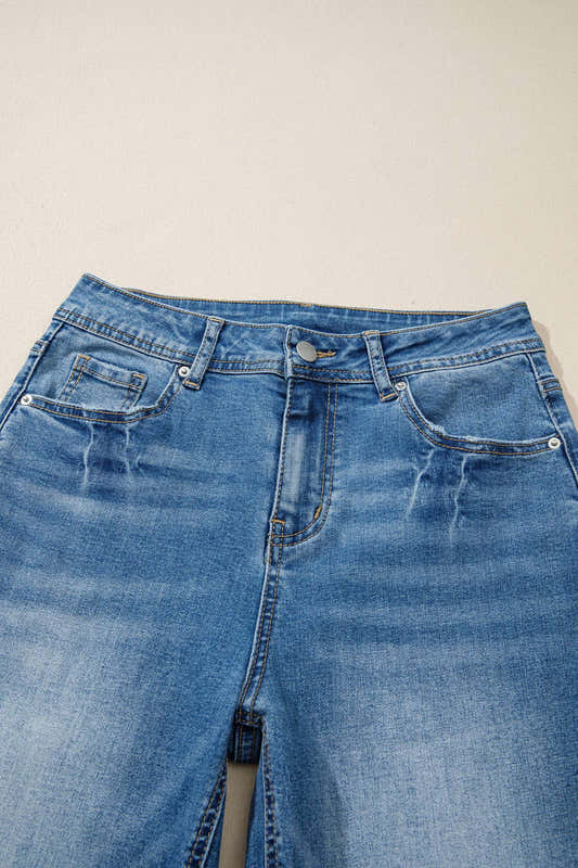 Jean taille haute bleu myosotis, ceinture avec passants et boutons à rivets.
