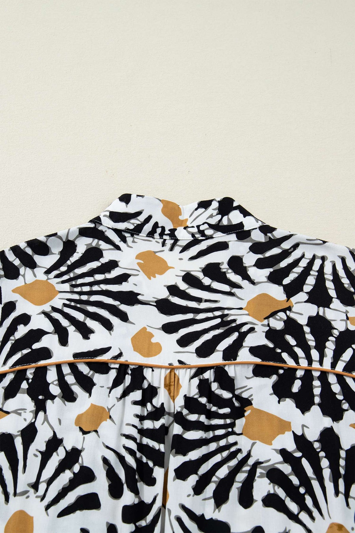 Robe à motifs floraux abstraits noir, blanc et ocre, col V