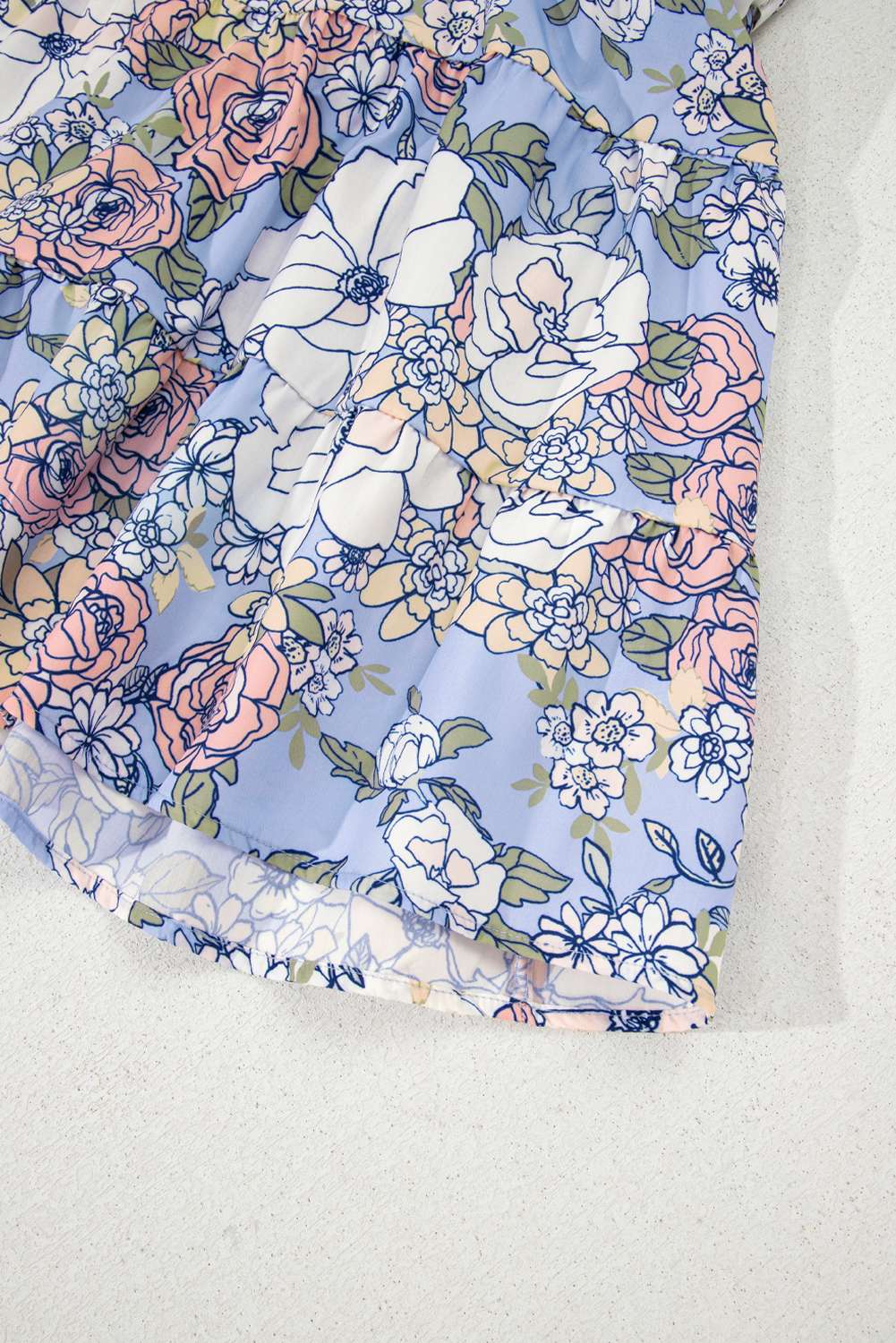 Ourlet de robe bleu ciel à motif floral pastel, bord légèrement froncé