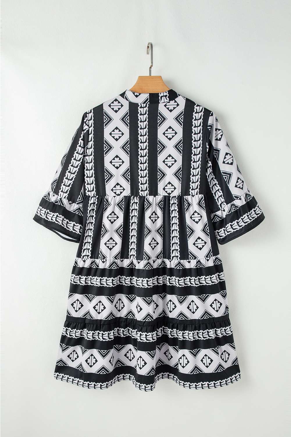 Robe noire à motifs géométriques, dos, manches évasées à volants