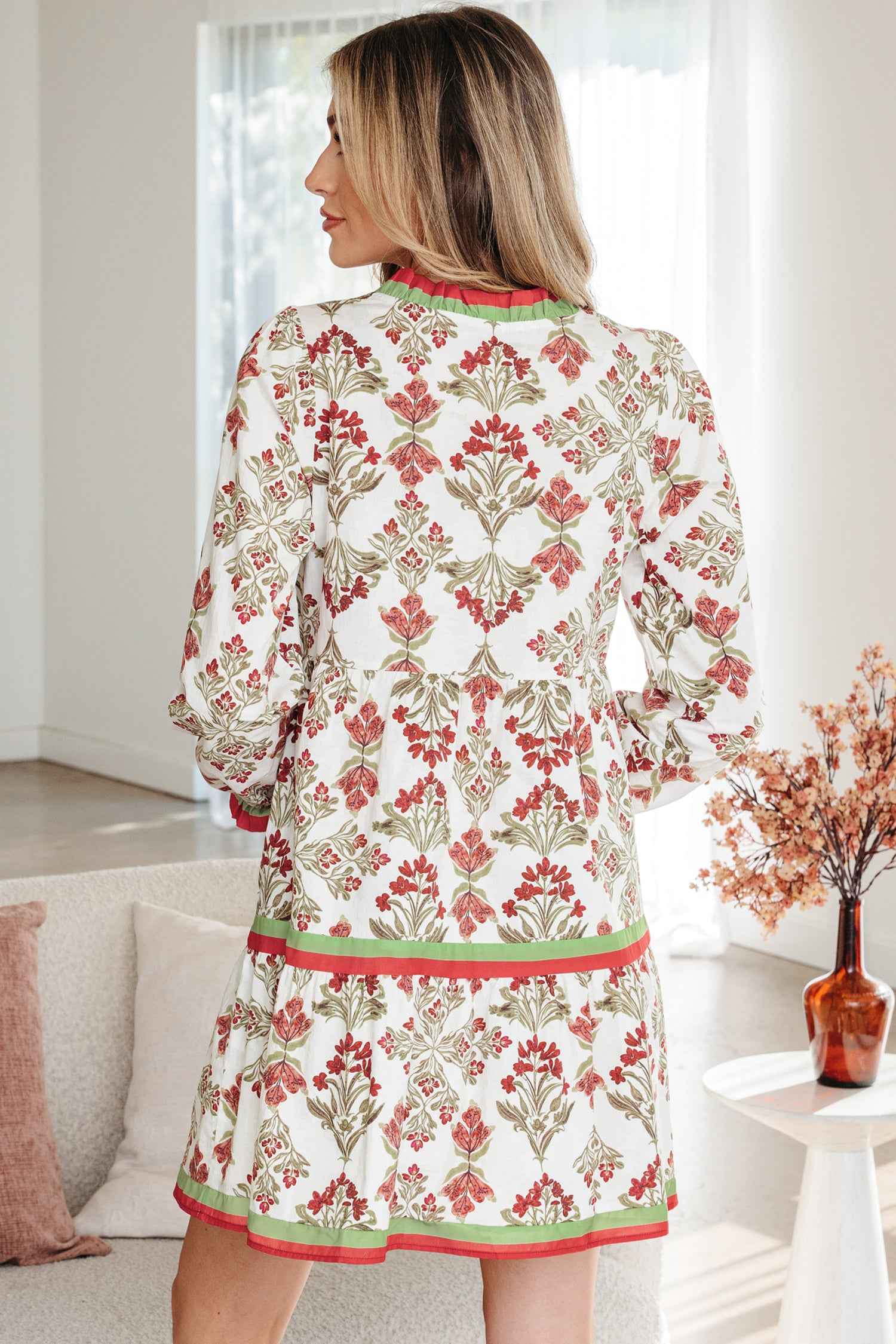 Robe dos imprimé en coton écru à fleurs rouges, liseré vert et ourlet contrasté.