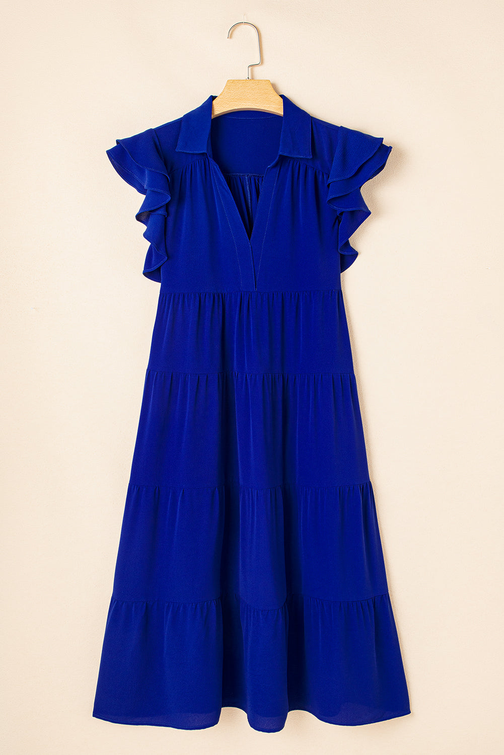 Robe midi bleue sur cintre, encolure V, manches volantées et volants étagés.