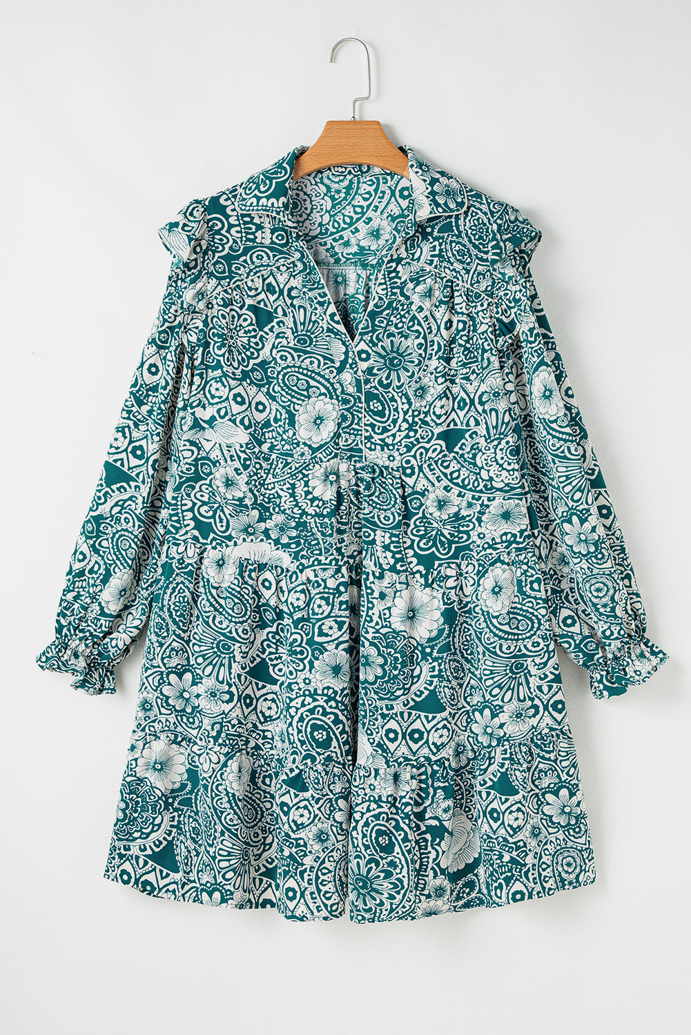 Robe turquoise à imprimé floral, col V avec boutons, dos et manches longues sur cintre.