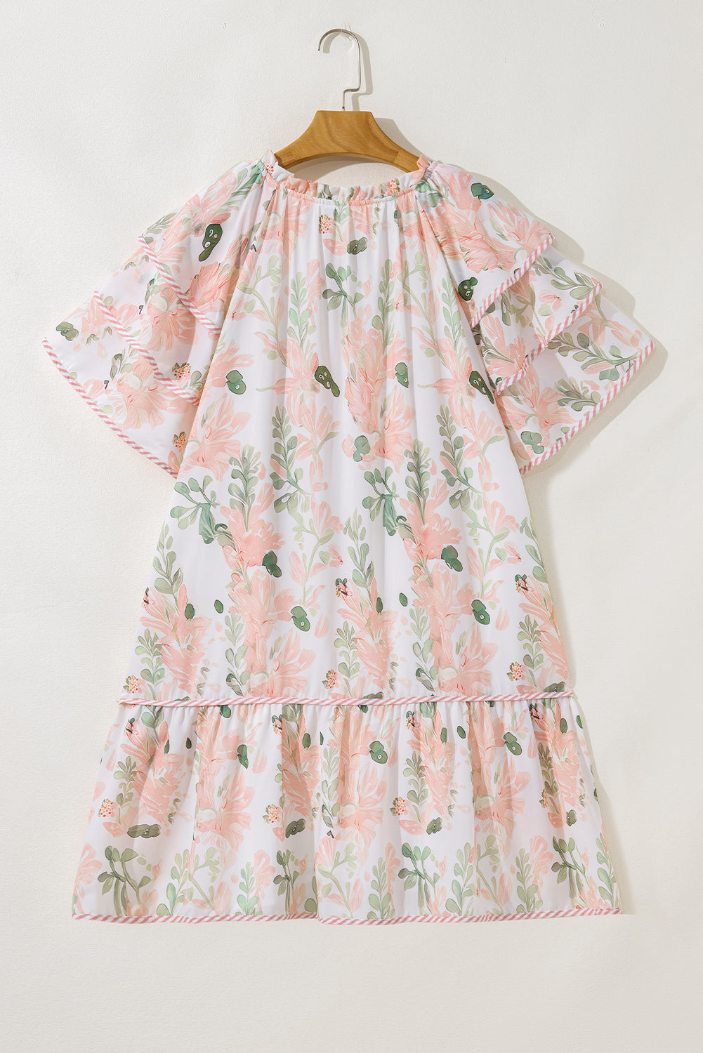 Robe courte rose à fleurs, encolure froncée, jupe à volants superposés.