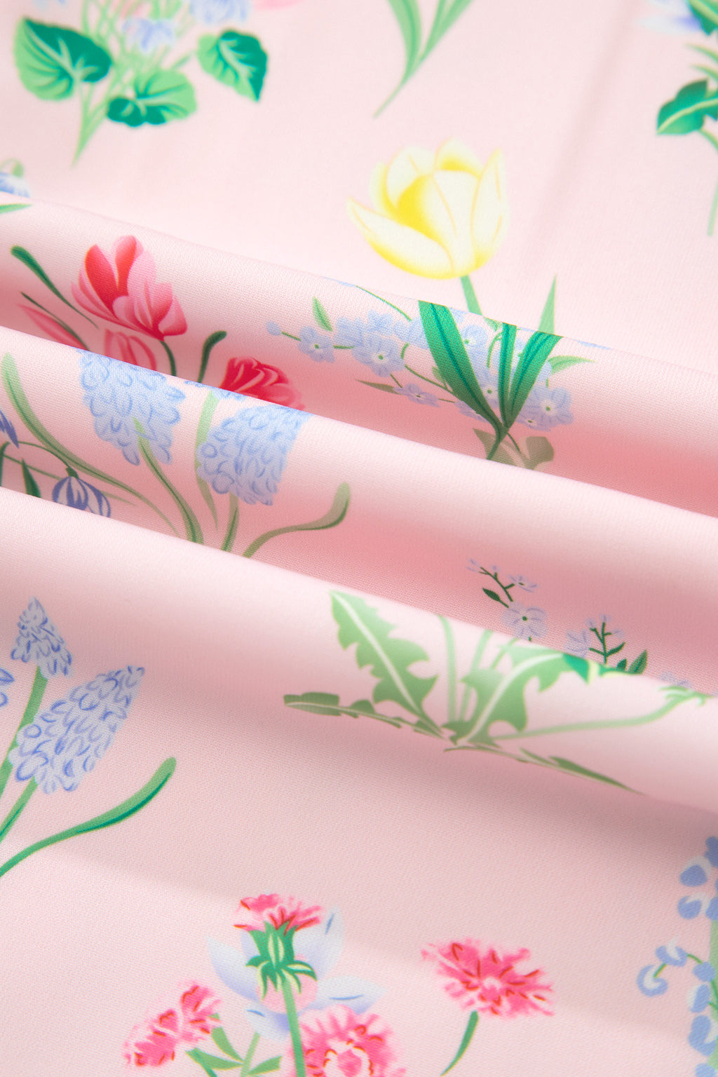 Tissu rose à fleurs multicolores et feuillages verts, motifs botaniques.