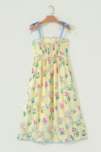 Robe midi à bretelles crème, fleurs multicolores, taille haute froncée, bord bleu.