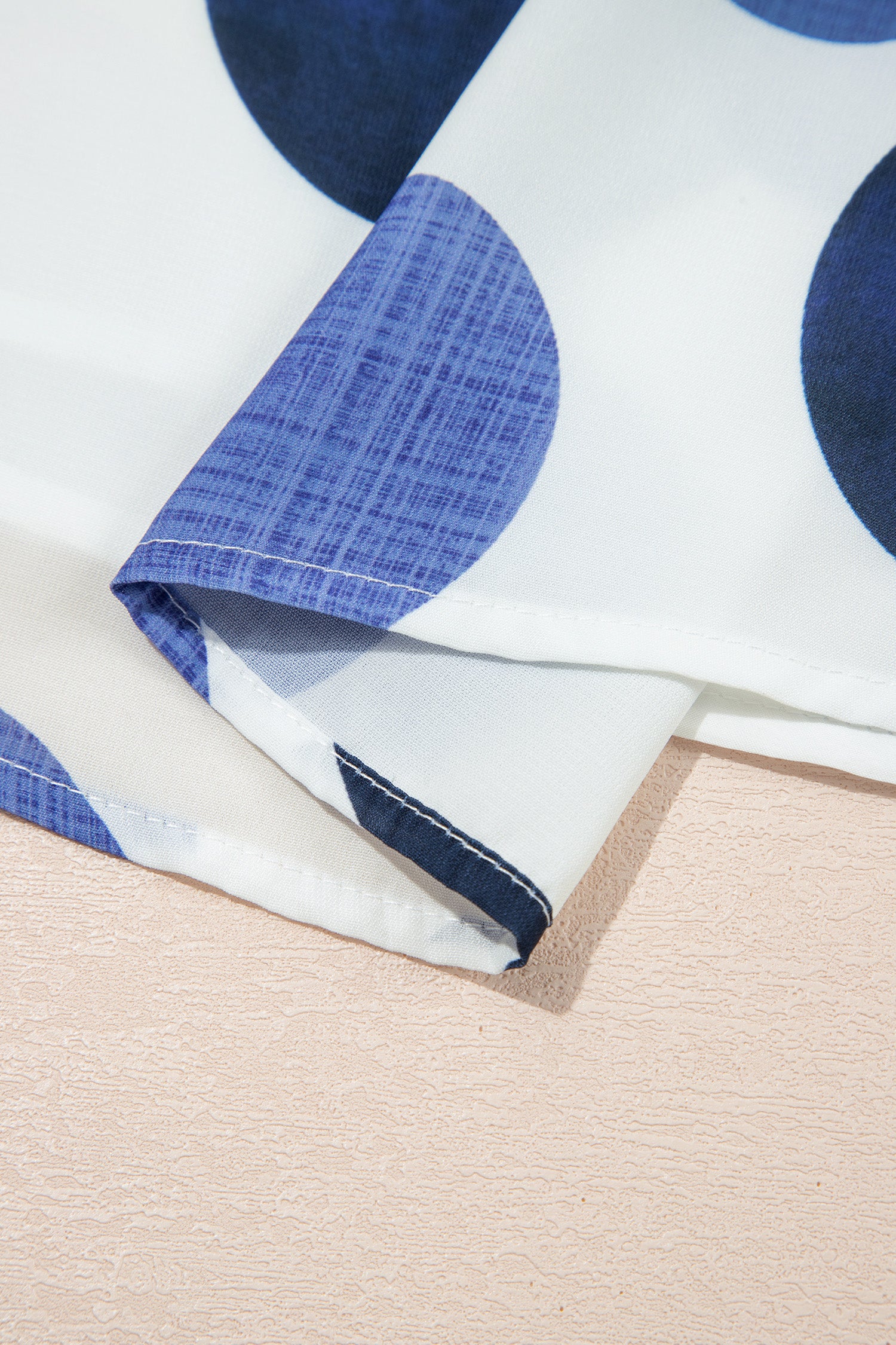 Ourlet et manchettes de robe blanche à pois bleu