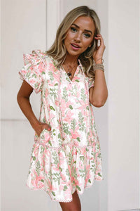 Robe courte à fleurs rose, manches volantées, col V, base évasée avec volants.