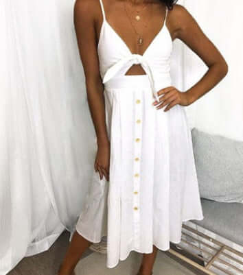 Robe longue dos nu blanche, bretelles à nœud, encolure en V, boutons devant, coupe fourreau.