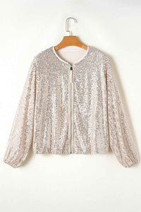 Veste à sequins argentée sur cintre, manches longues, col rond, fermeture centrale.