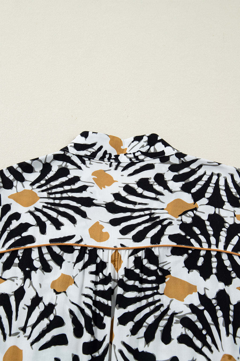 Robe à motifs floraux abstraits noir, blanc et ocre, col V