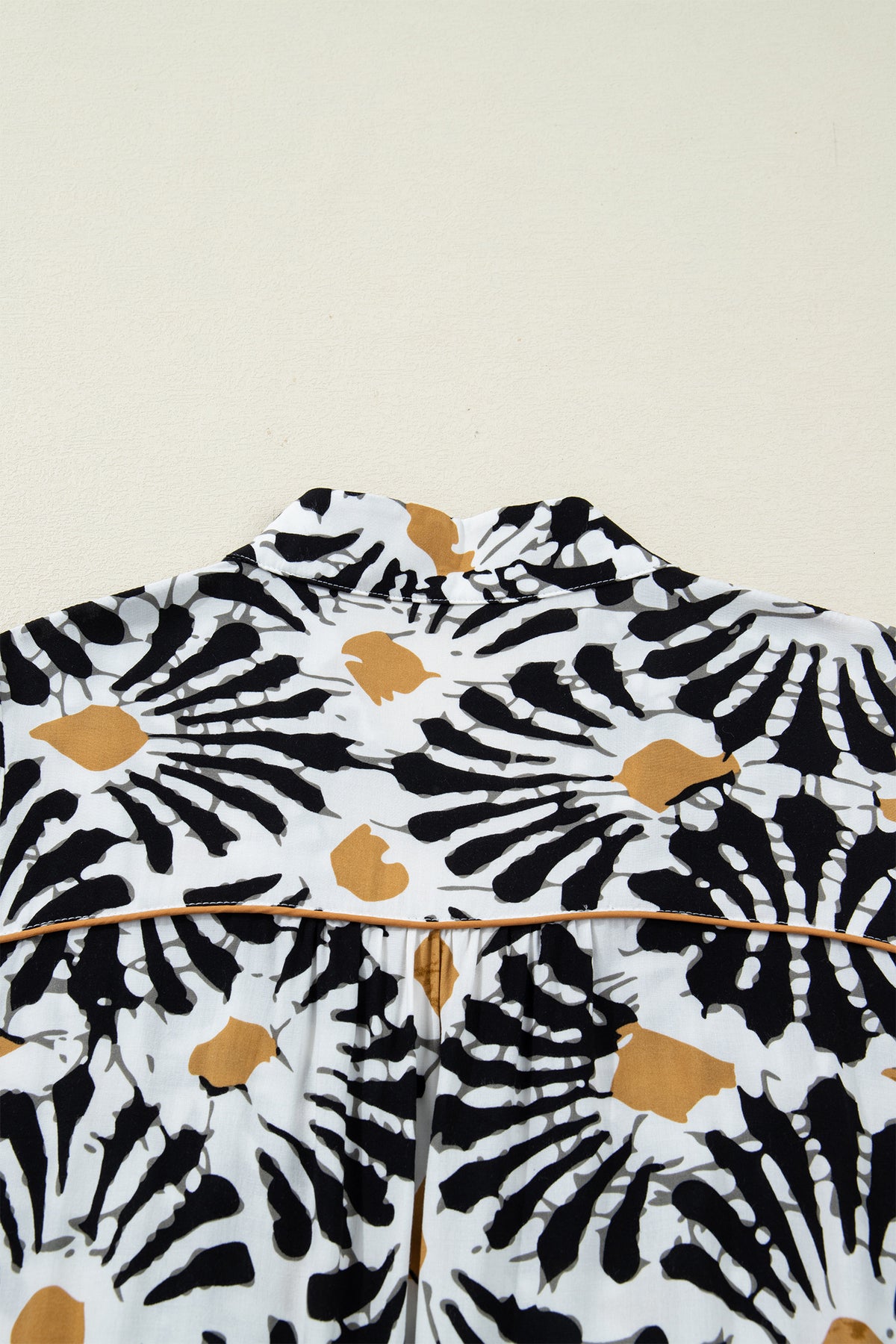 Robe à motifs floraux abstraits noir, blanc et ocre, col V