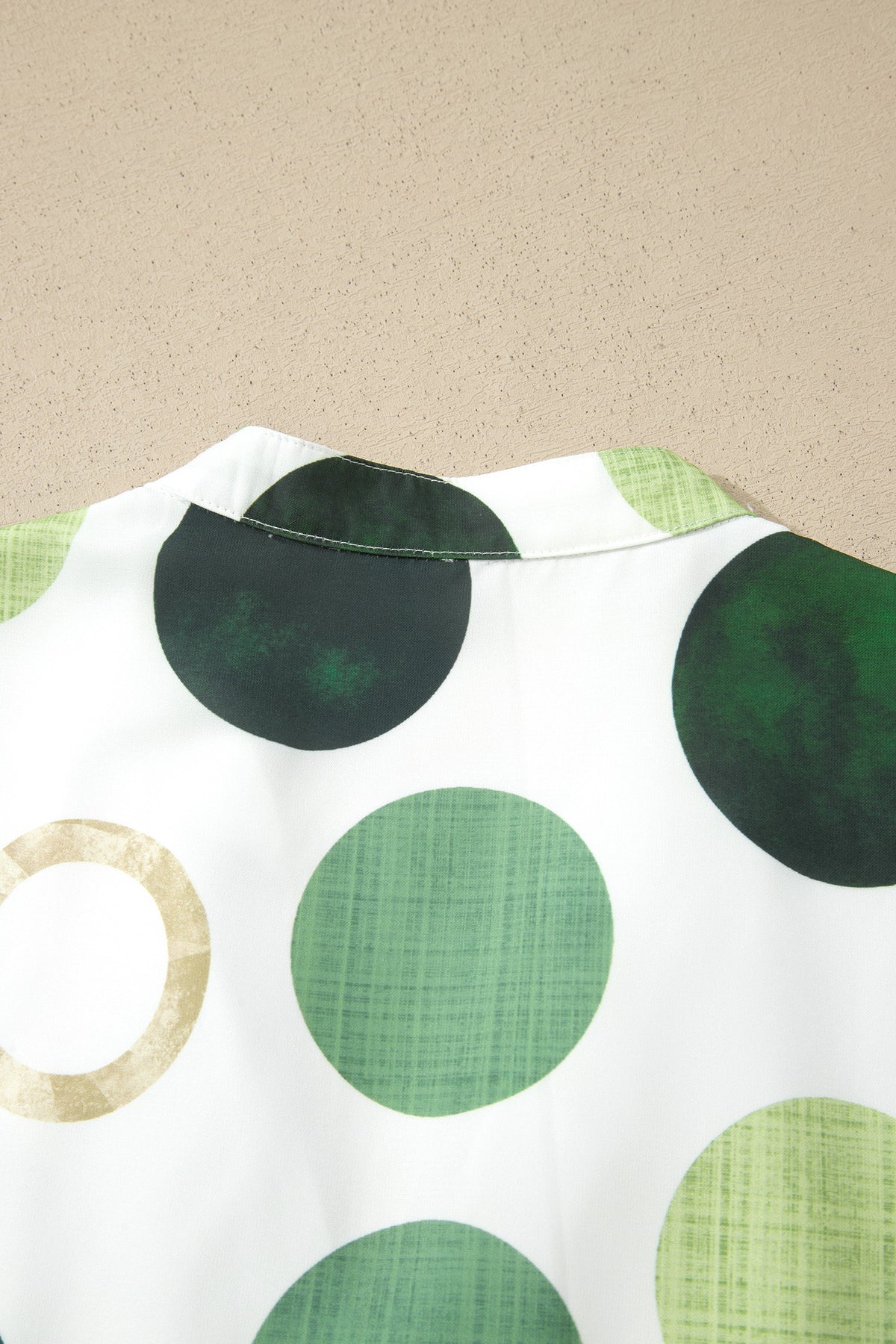 Encolure et buste de robe blanche à gros pois verts et cercles beiges