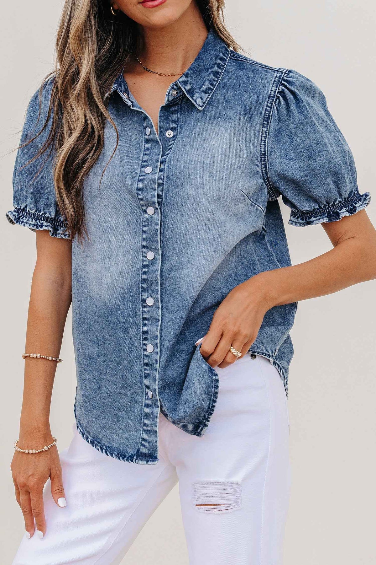 Chemisier en denim bleu à col et manches courtes bouffantes, boutons-pression.