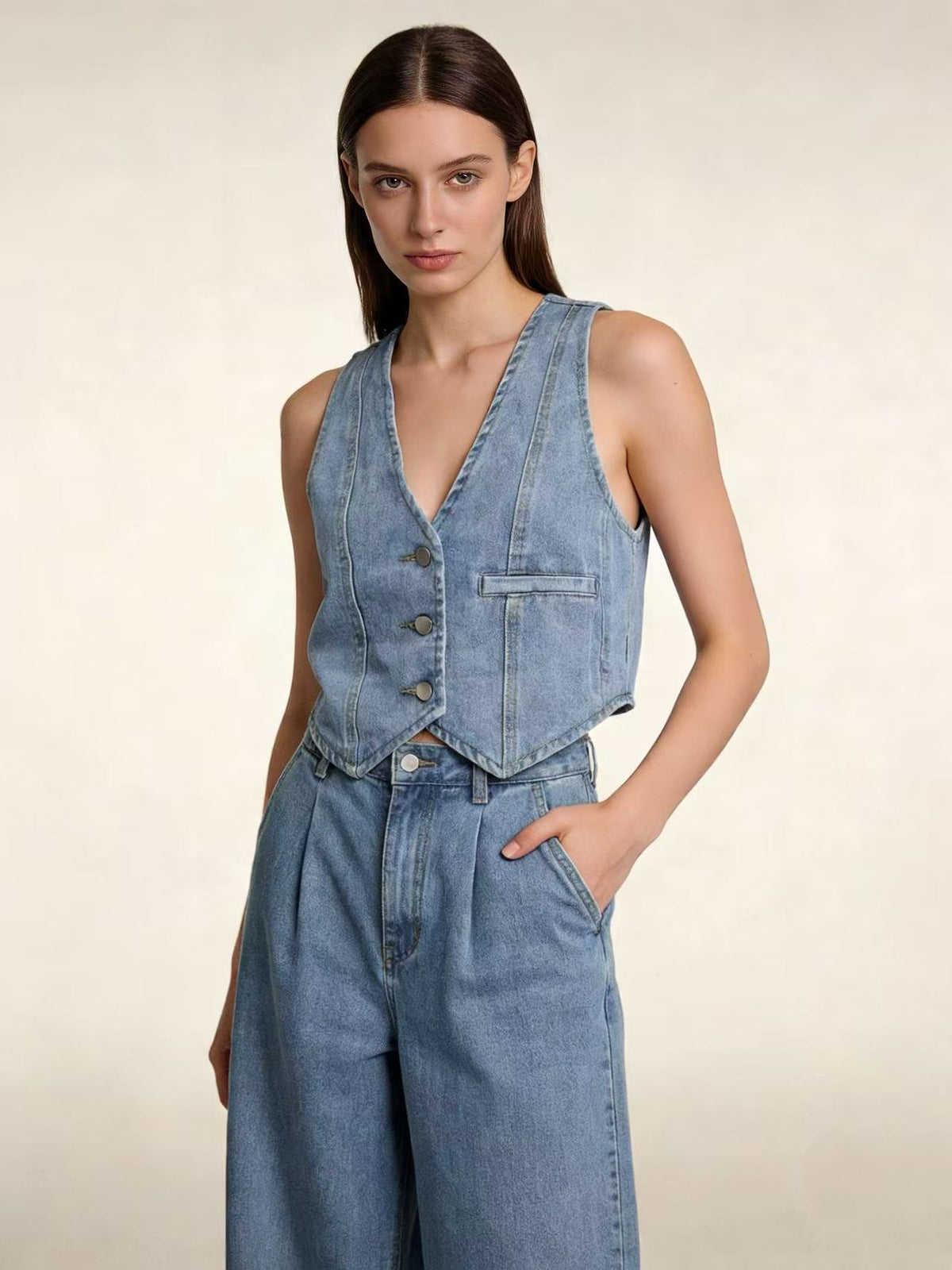 Gilet en jean bleu moyen sans manches, encolure V, boutonnage devant et poche poitrine