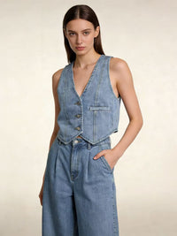 Gilet en jean bleu moyen sans manches, encolure V, boutonnage devant et poche poitrine
