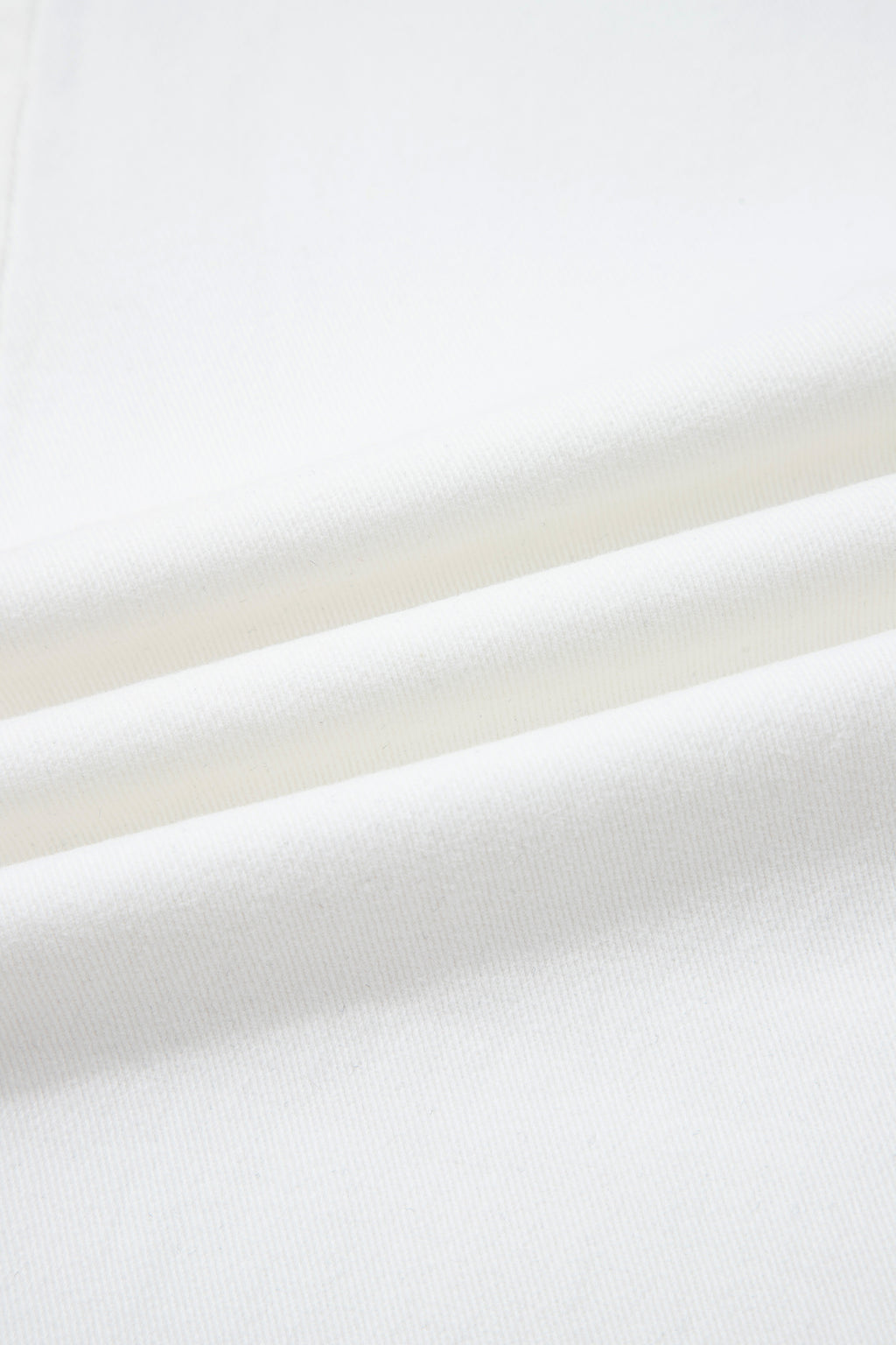 Denim blanc, gros plan sur la texture du tissu, surface lisse et dense.