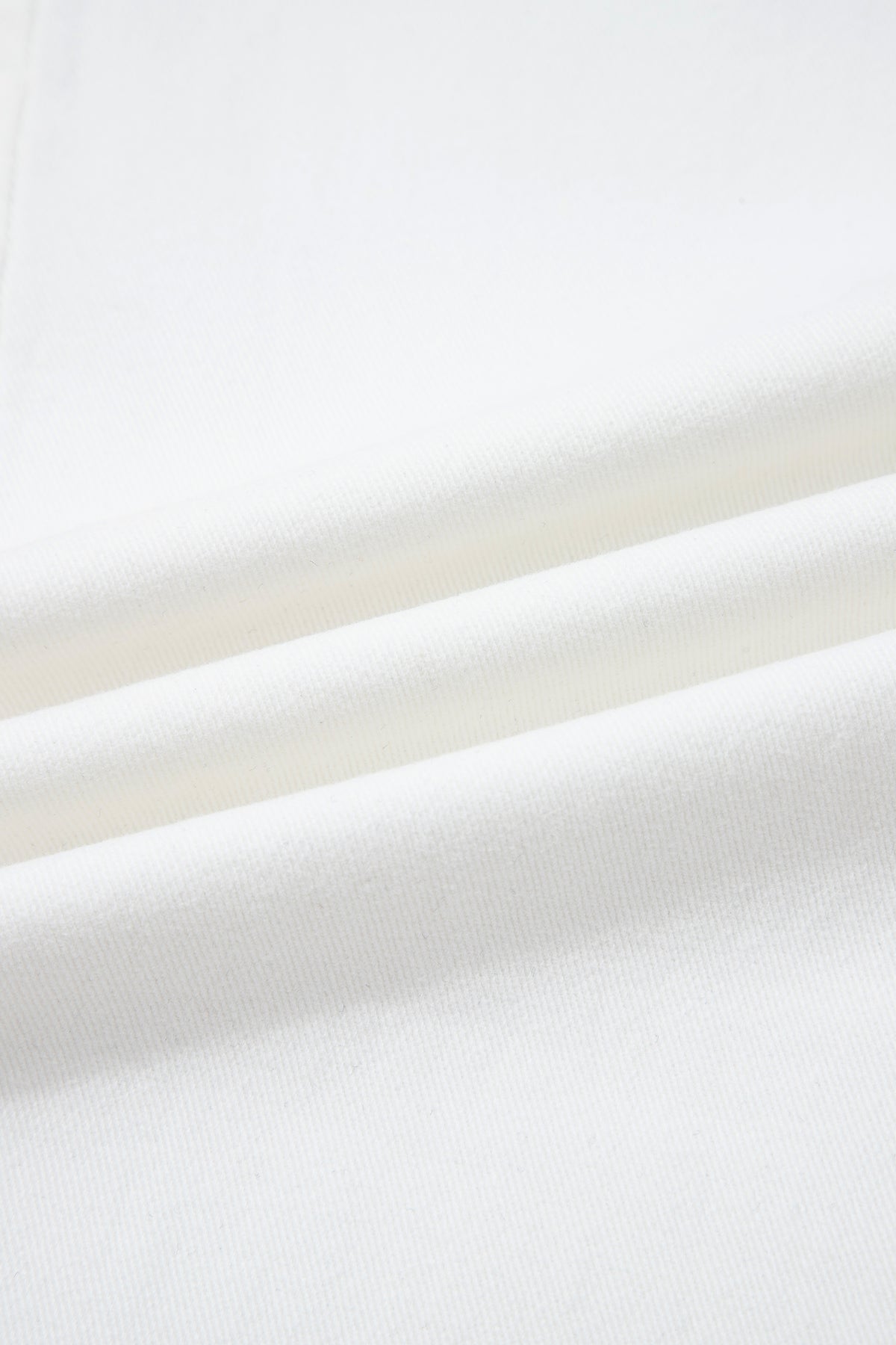 Denim blanc, gros plan sur la texture du tissu, surface lisse et dense.