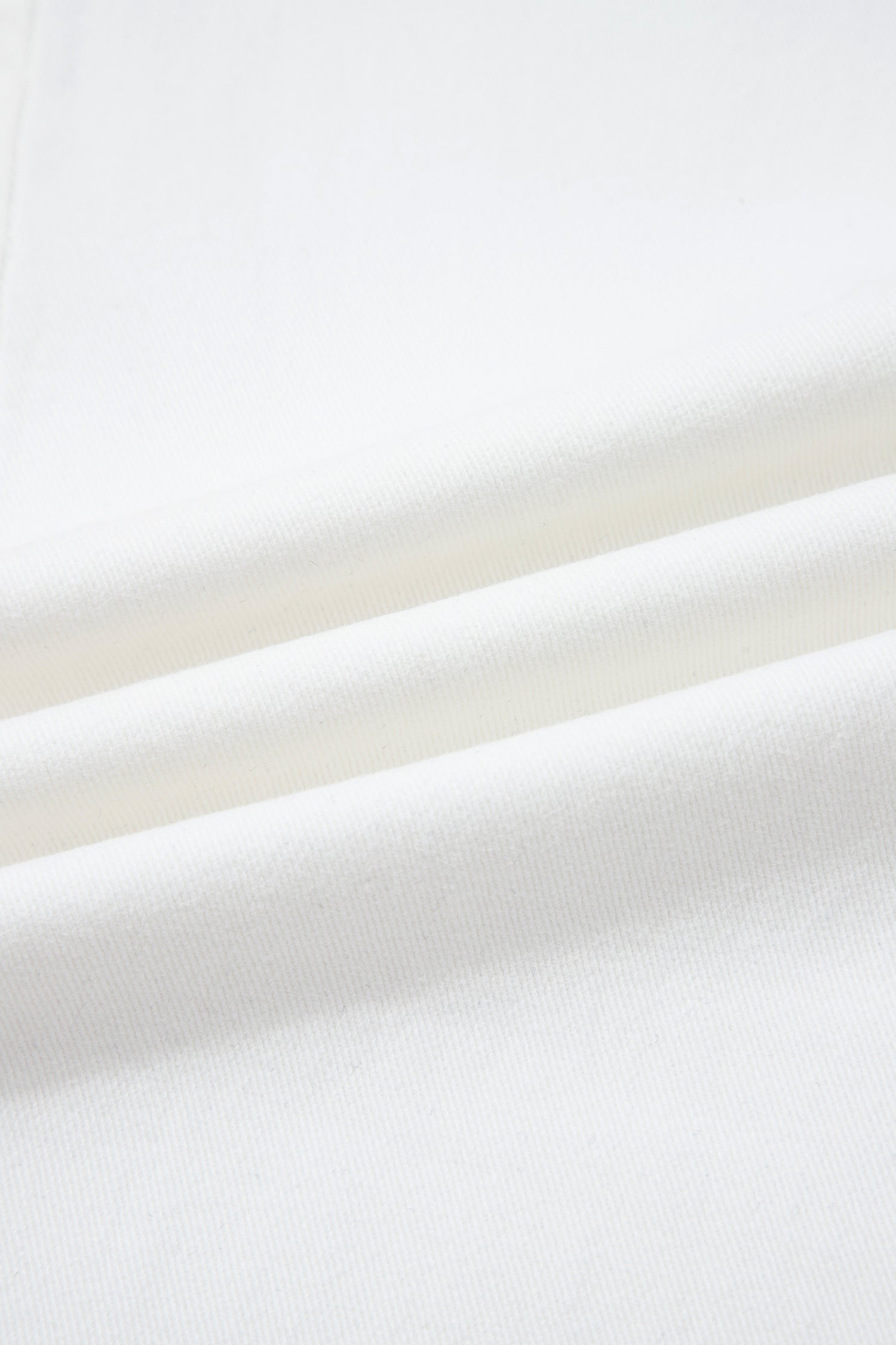 Denim blanc, gros plan sur la texture du tissu, surface lisse et dense.