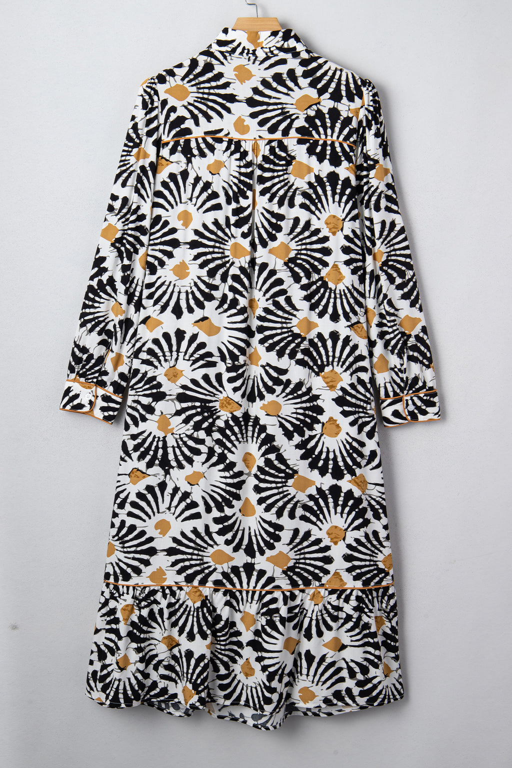 Robe longue sur cintre, vue dos, manches longues, motifs floraux abstraits noir/blanc