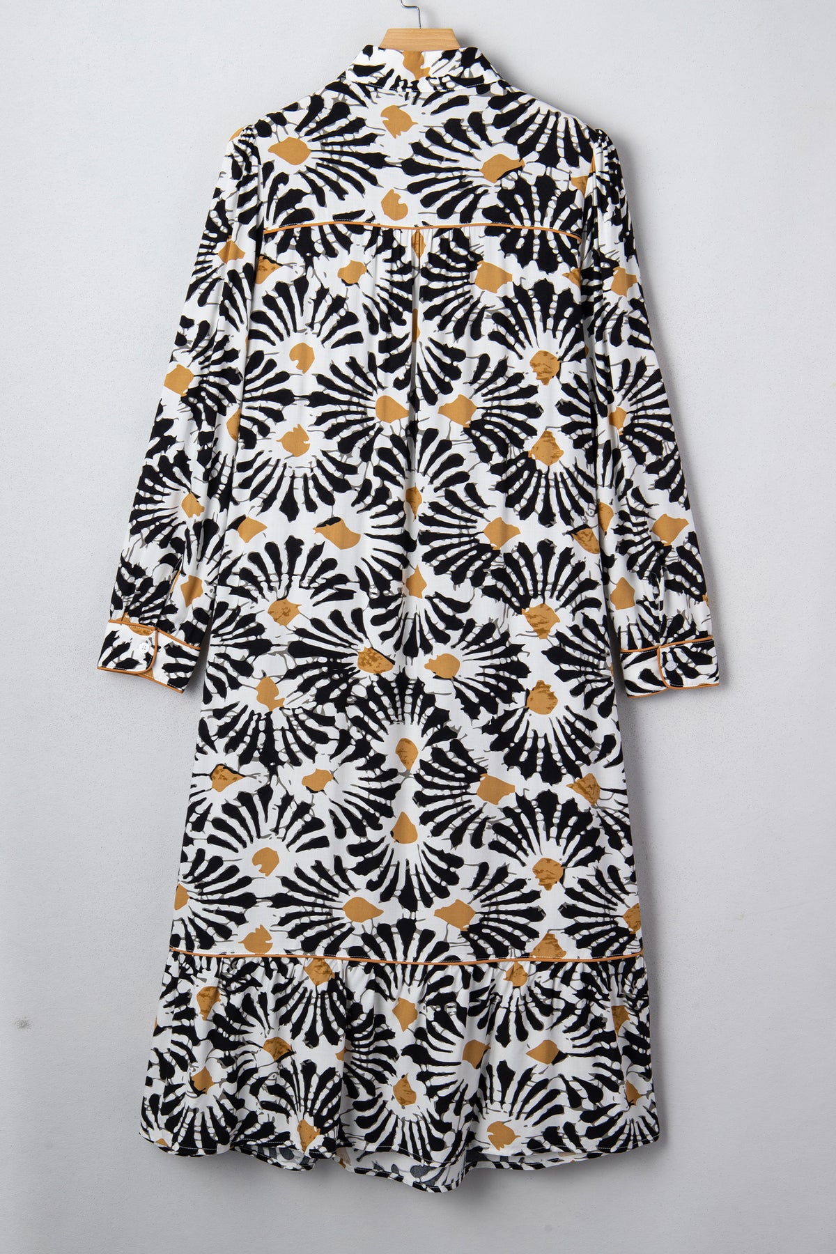 Robe longue sur cintre, vue dos, manches longues, motifs floraux abstraits noir/blanc