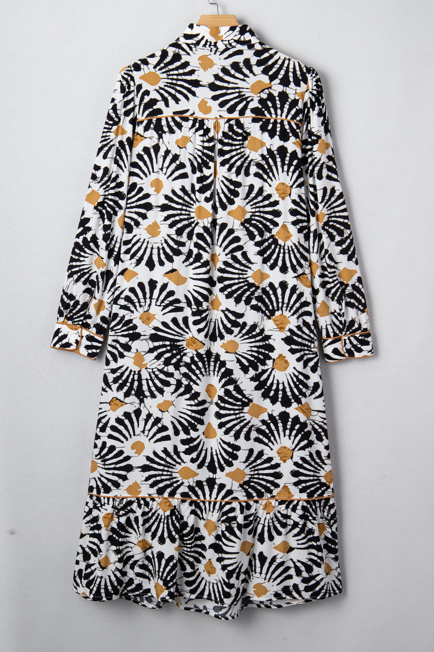 Robe longue sur cintre, vue dos, manches longues, motifs floraux abstraits noir/blanc