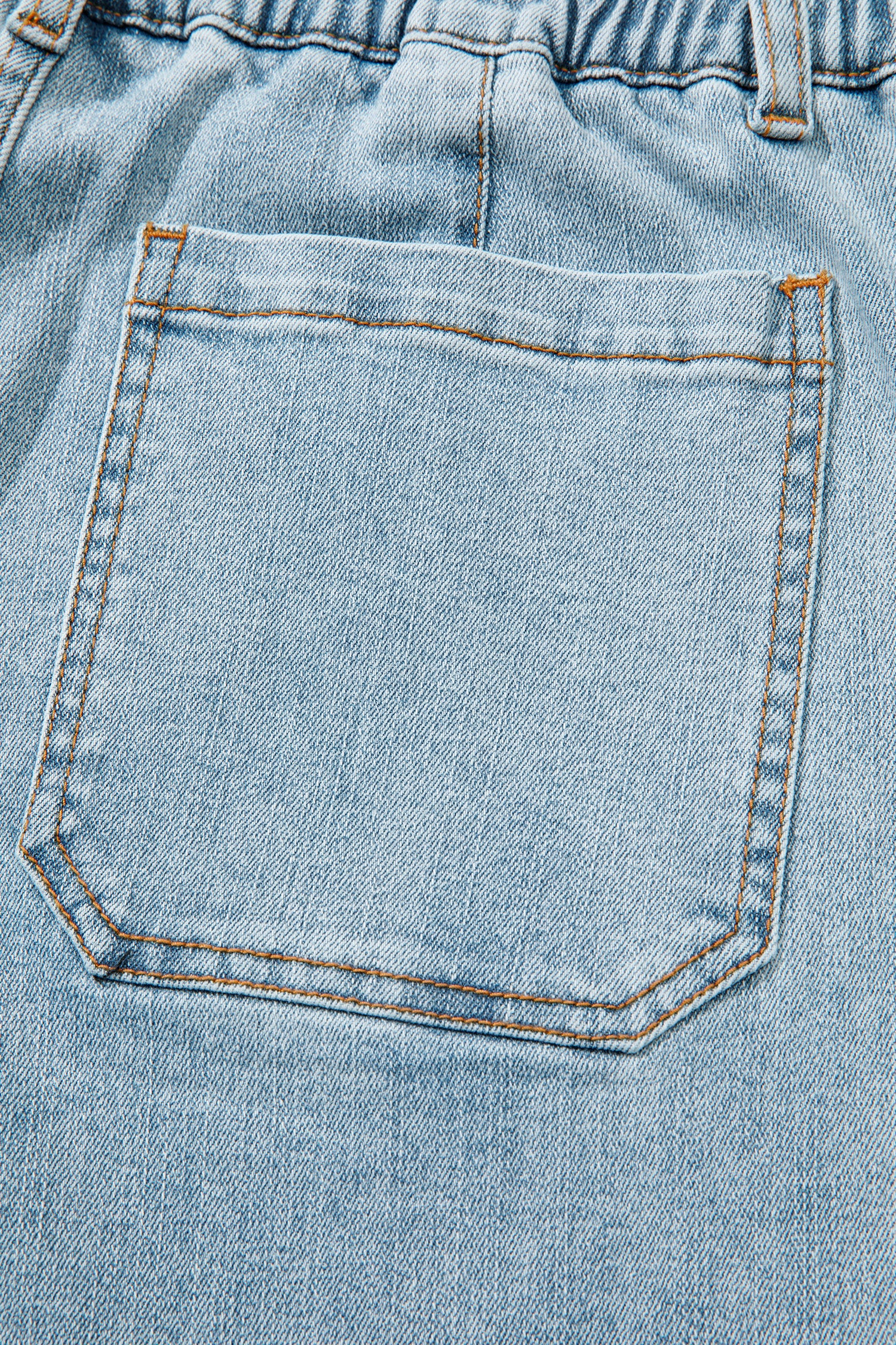 Jean bleu ciel : poche avant carrée avec surpiqûres et coutures orange.