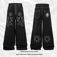 Pantalon jean femme noir large, broderies florales sur l’avant et l’arrière, jambe droite.
