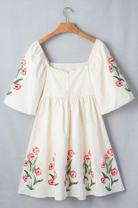 Robe babydoll crème avec manches bouffantes à fleurs rouges et encolure carrée.