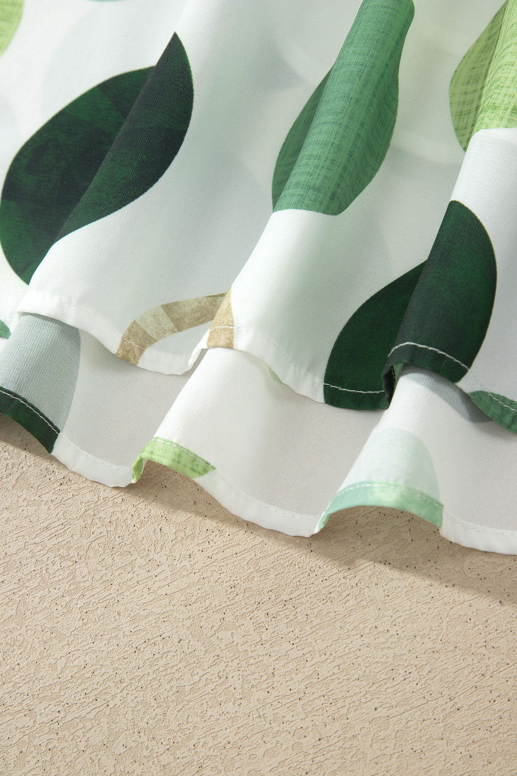 Ourlet évasé de robe blanche à gros pois verts, tissu léger