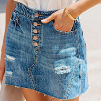 Jupe en jean courte bleu foncé, taille mi-haute, boutonnage devant, poches et déchirures