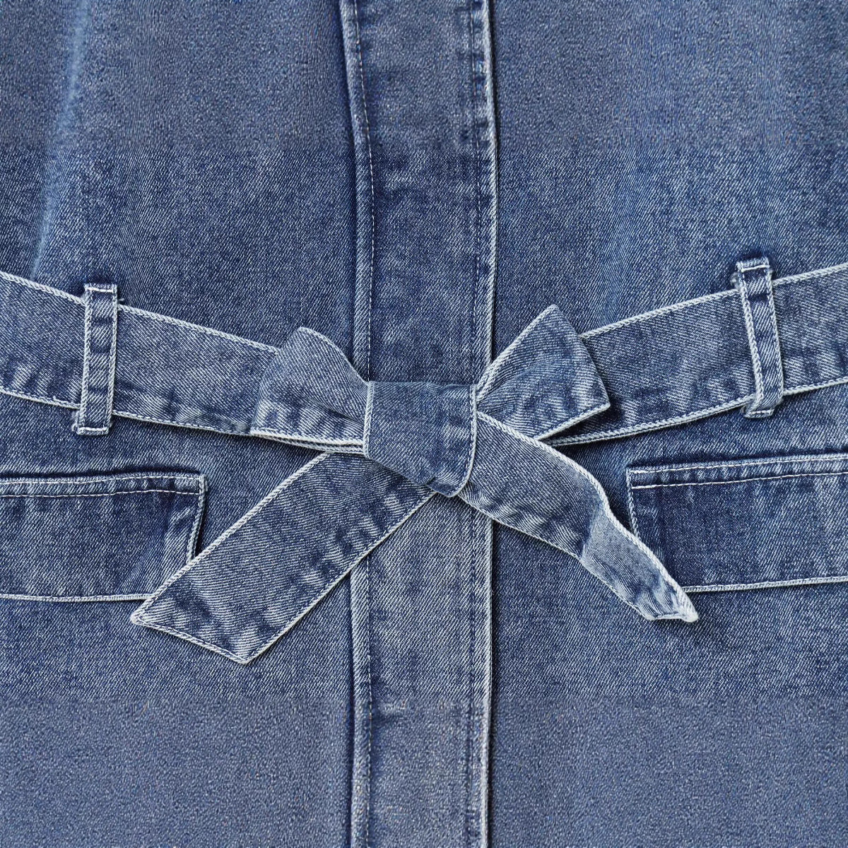 Ceinture nouée en jean bleu sur la veste, liens et passants en tissu