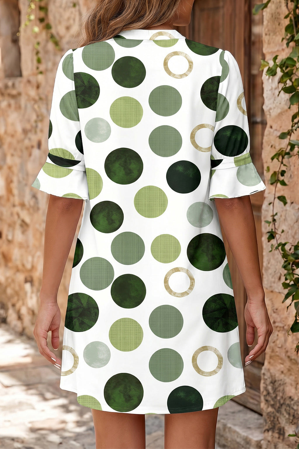 Robe mini à pois verts, vue de dos, manches courtes évasées, ourlet évasé.