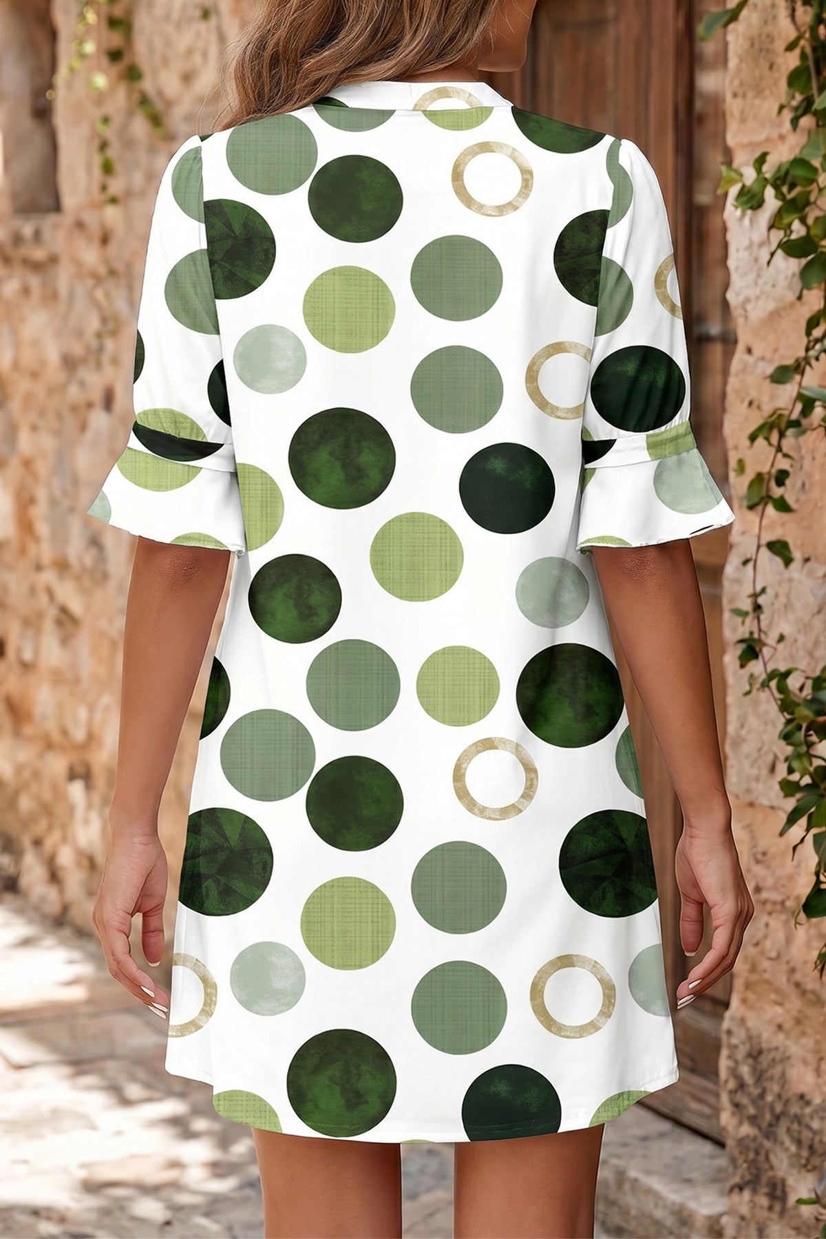 Robe mini à pois verts, vue de dos, manches courtes évasées, ourlet évasé.