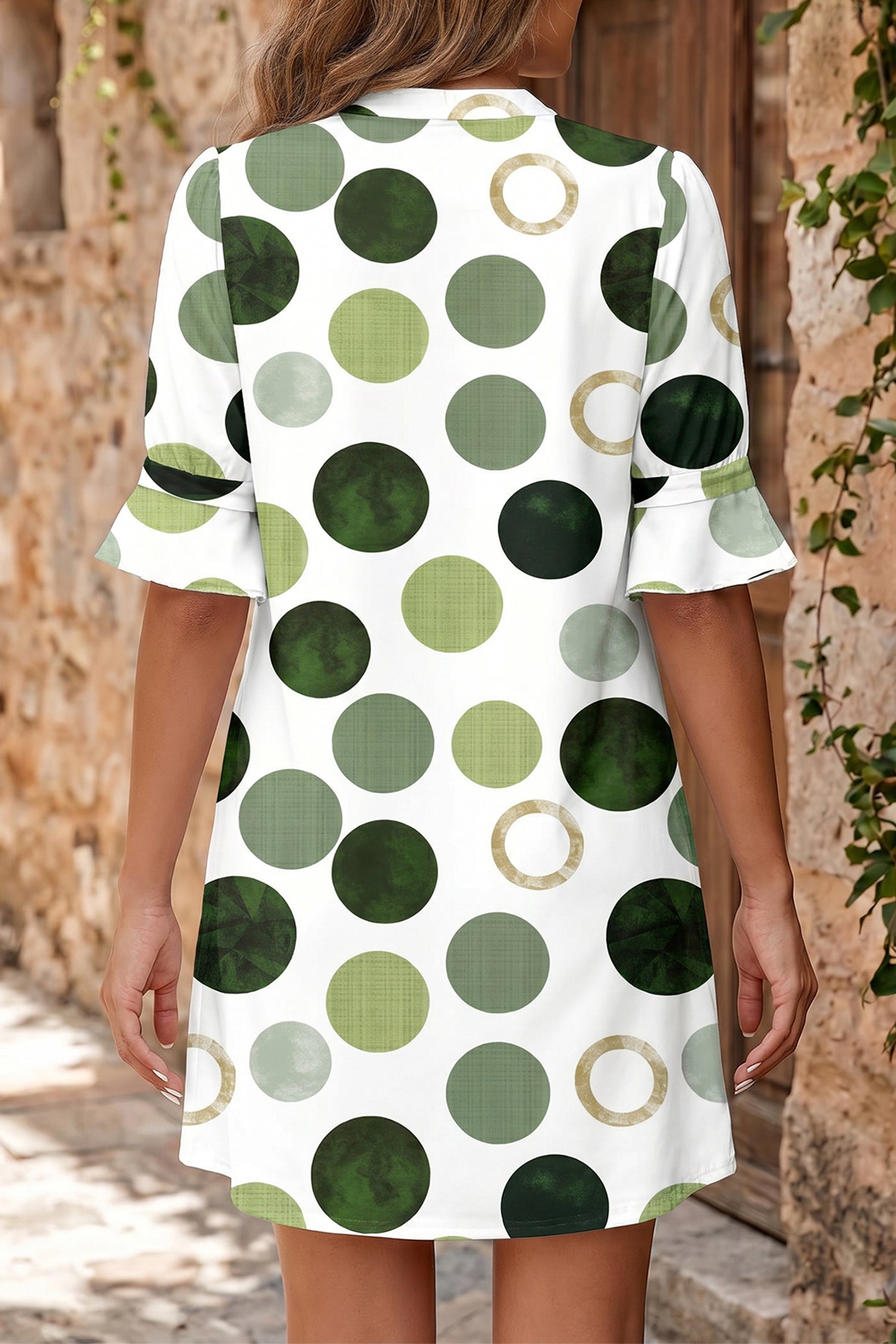 Robe mini à pois verts, vue de dos, manches courtes évasées, ourlet évasé.