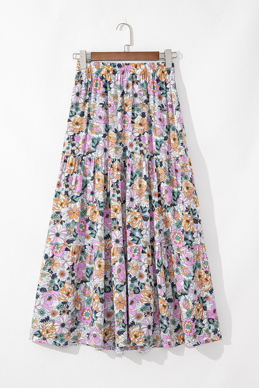 Jupe longue imprimée florale multicolore sur fond bleu, taille élastique et volants.