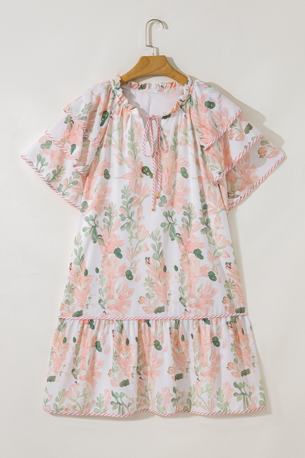 Robe courte rose à fleurs, manches volantées, encolure froncée et jupe évasée.