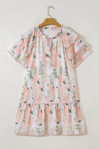 Robe courte rose à fleurs, manches volantées, encolure froncée et jupe évasée.