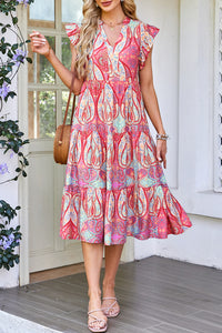 Robe mi-longue rose motif paisley, col en V, manches volantées, jupe à volants superposés.