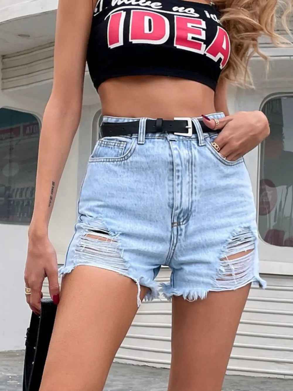 Short en jean bleu clair à taille ceinturée, fermeture boutonnée, déchirures, ourlet effiloché