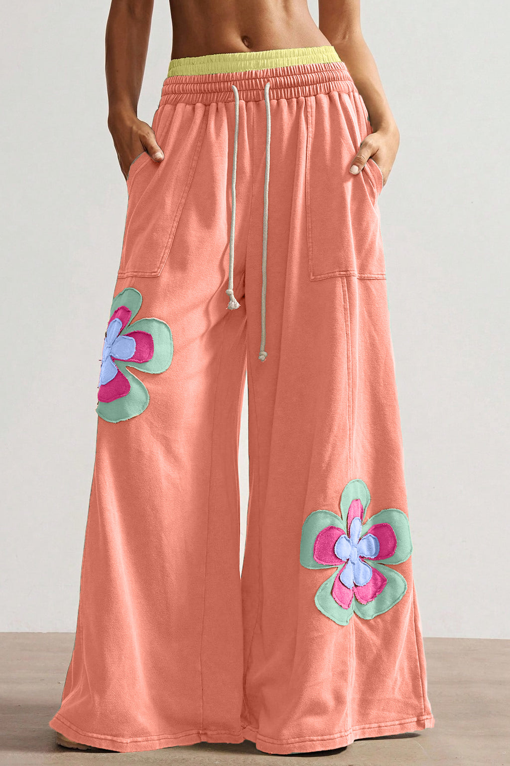 Pantalon ample corail à fleurs appliquées, taille élastique avec cordon, jambes larges.